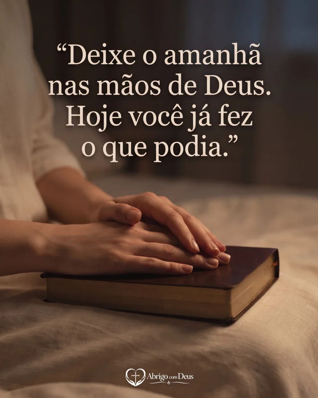 Cartão com mãos repousadas sobre uma Bíblia fechada em ambiente acolhedor e mensagem para deixar o amanhã nas mãos de Deus.